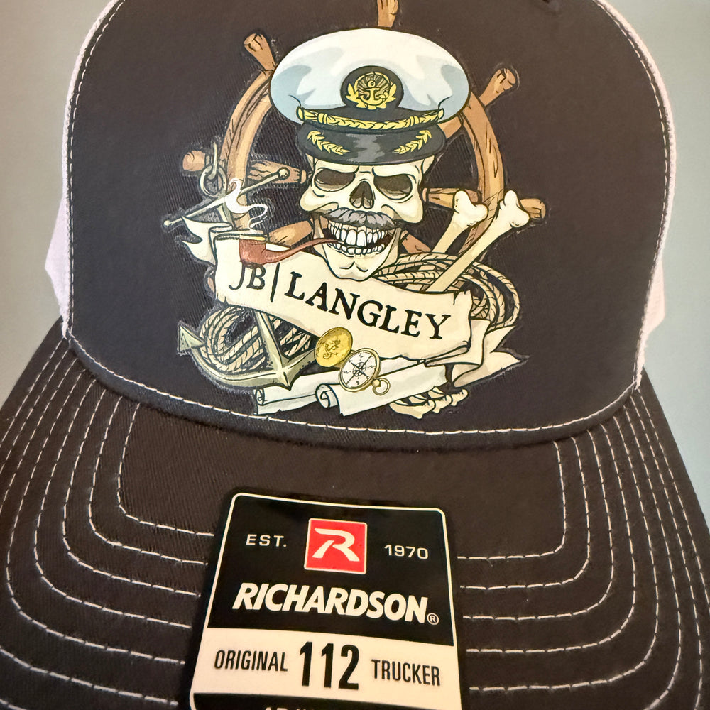 Black cap with a skull and crossbones design and Richardson label on a light gray background
